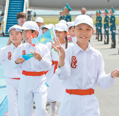 7月2日,哈萨克斯坦儿童在阿斯塔纳机场热烈欢迎习近平主席到访。本报记者 王洲 摄